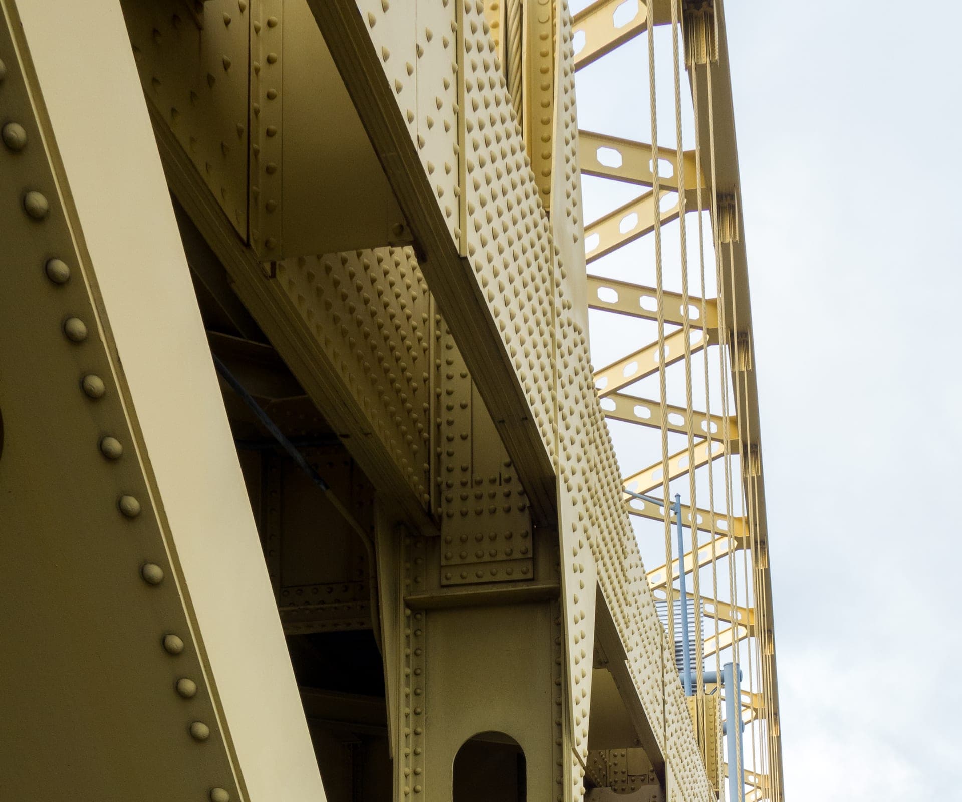 Illuminated Fort Pitt Bridge walkway at dusk with the downtown skyline beyond